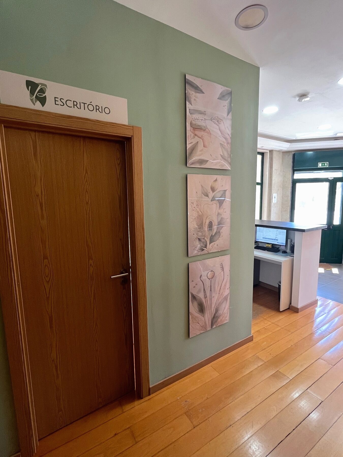 Corredor da clínica com placa de escritório e arte na parede